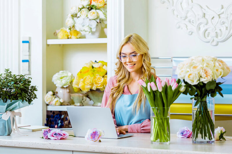 A small business owner manages her floral shop online, illustrating the need for reliable IT support for small businesses