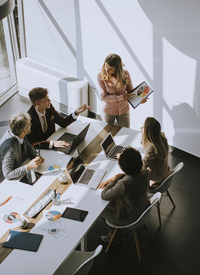 Business professionals in a modern office using laptops and discussing wi-fi design services in Japan for seamless connectivity