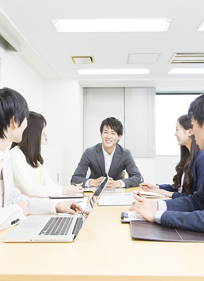 Business professionals strategizing cloud computing solutions with digital overlays representing cloud networks and automation in Japan.