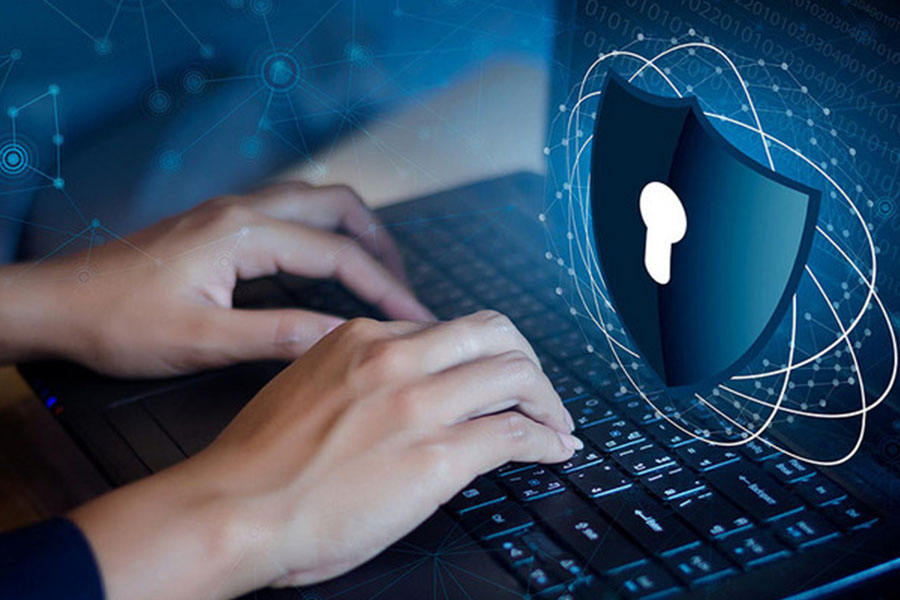 Man typing on computer with a padlock icon concept image for cyber security