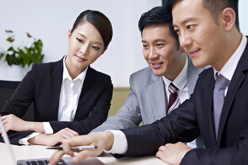 Professionals from an IT company in Hong Kong discussing over a laptop