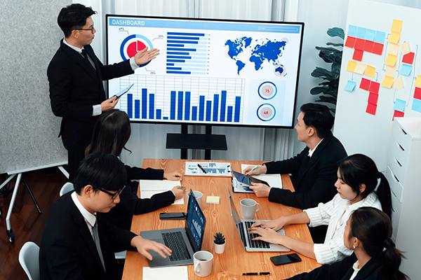 Project manager in Tokyo presenting to a team in a modern Japanese office.