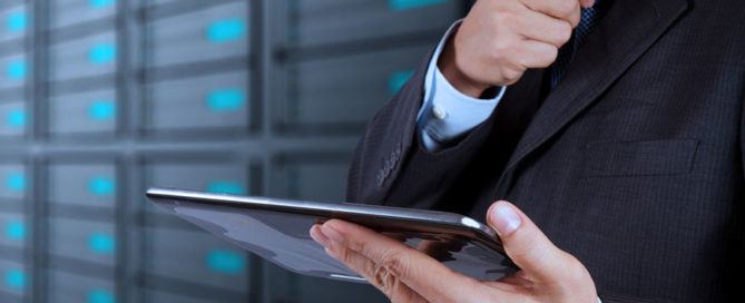 IT network professional wearing suit and tie holding tablet